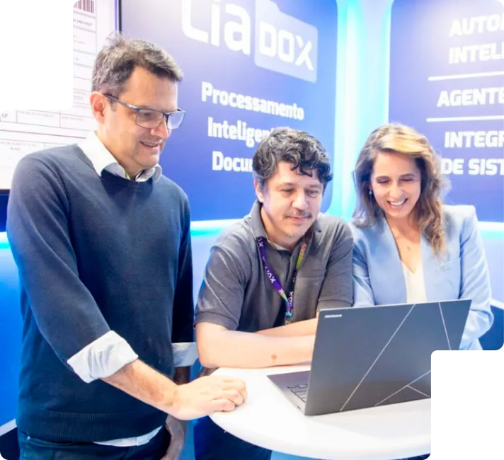 Clientes da Liax diante de um notebook no estande da empresa